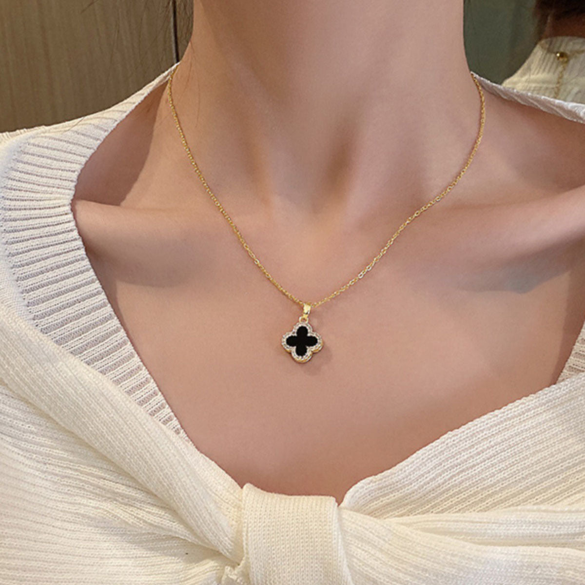 Four-leaf clover necklace lying on a marble surface
