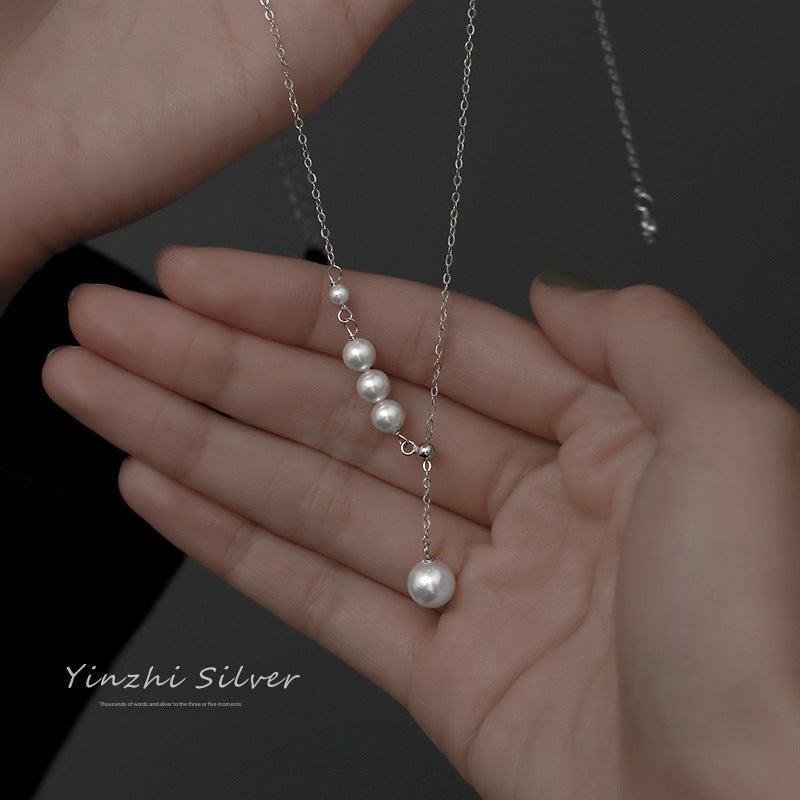Close-up of pearl detailing on silver necklace