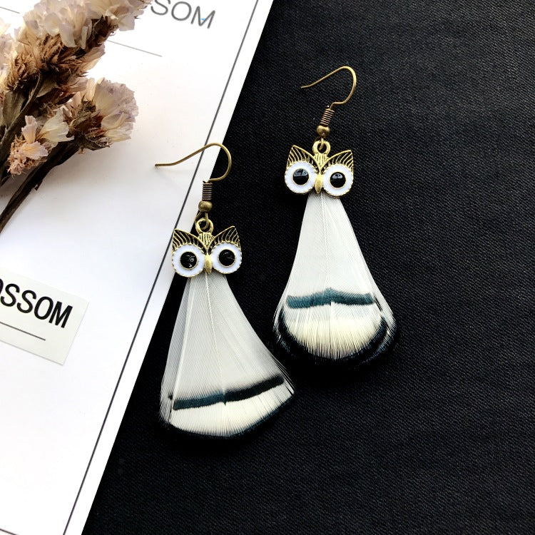 Peacock feather earrings displayed on a model